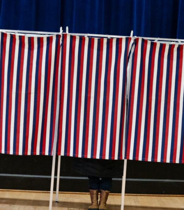 Shoes visible behind a voting booth.