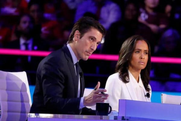 David Muir and Linsey Davis sit onstage behind a desk with an audience behind them.