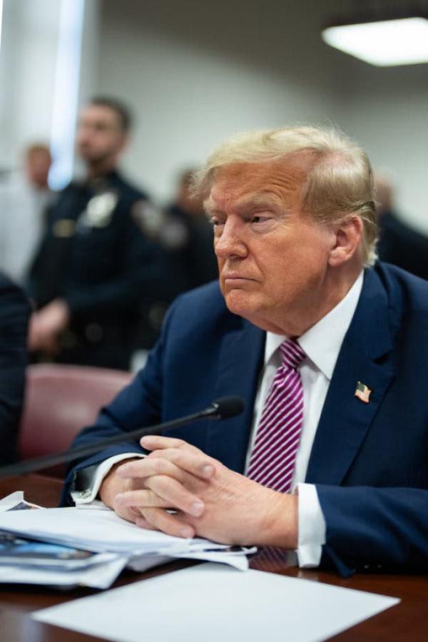 Trump at a courtroom table. Donald J.