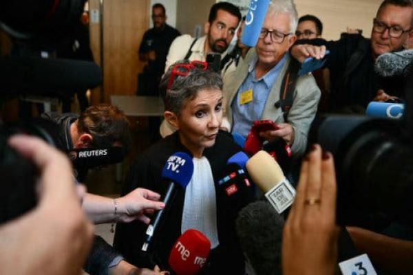 The lawyer Béatrice Zavarro speaks into a bunch of microphones.