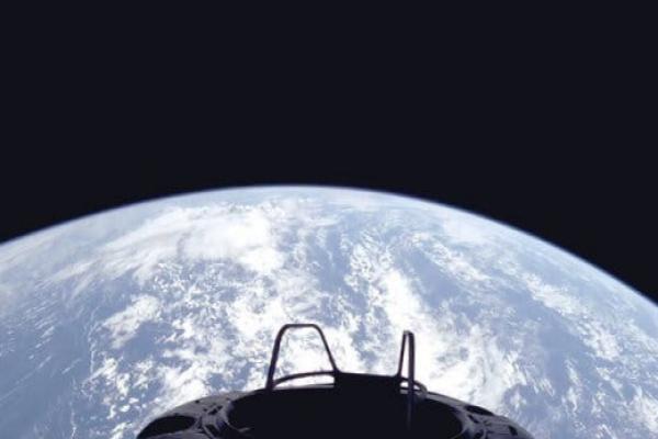 A view of Earth against the blackness of space with an area of spacecraft in the foreground.